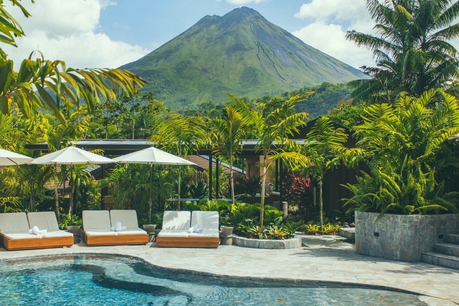 Arenal Volcano rising above the pool and tropical gardens at Nayara Gardens