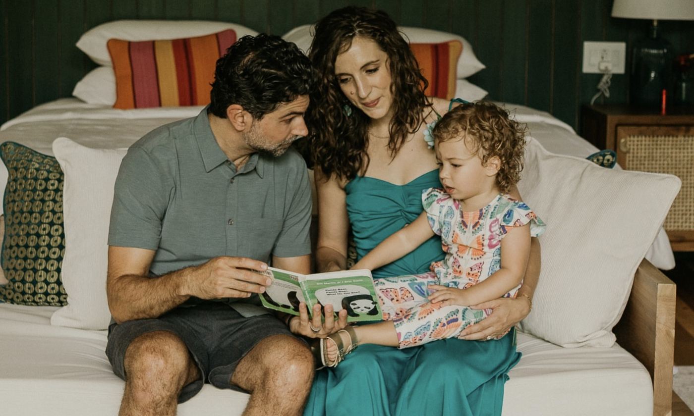 A family reading together in their room at Nayara Gardens